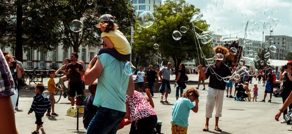 Children and adults enjoying bubbles at a street festival in Nantes, France.