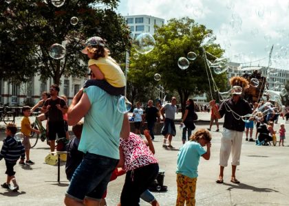 Children and adults enjoying bubbles at a street festival in Nantes, France.